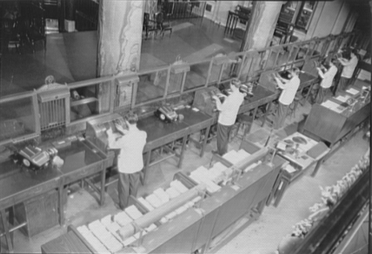 Bank tellers working at machines in a New York bank in 1941